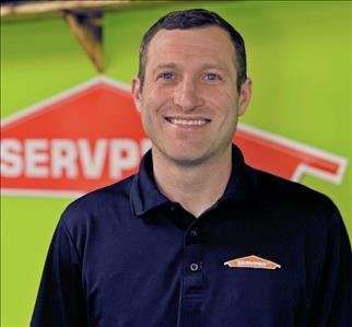 Black Shirt with Green wall and SERVPRO logo in the Background 